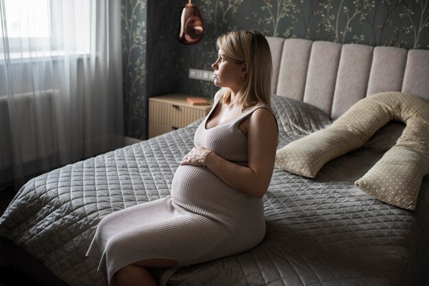 Medium shot pregnant woman sitting