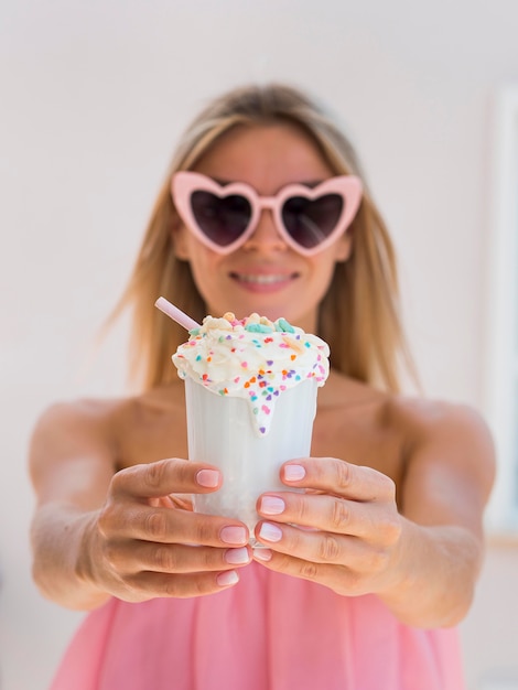 Free photo medium shot pretty girl holding milkshake