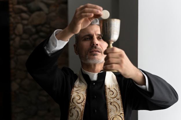 Free Photo medium shot priest holding eucharist