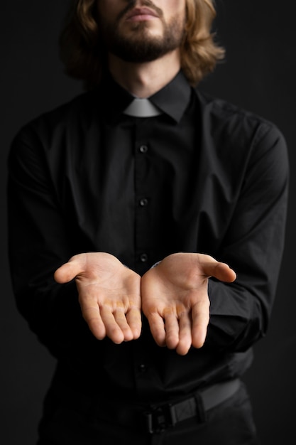 Free photo medium shot priest showing his hands