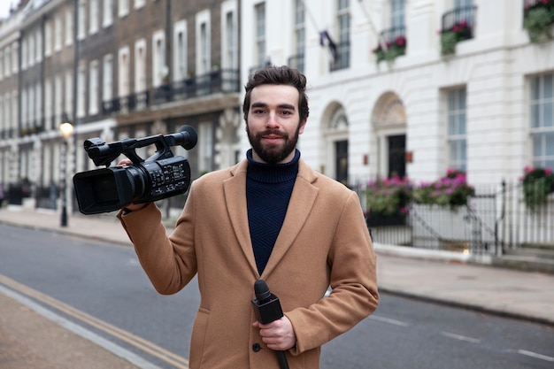 Free photo medium shot reporter holding video camera