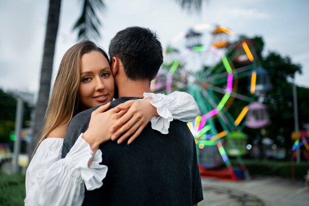 Medium shot romantic couple hugging in public