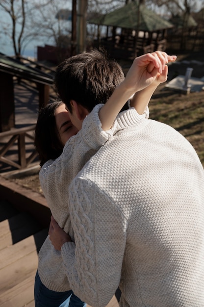 Medium shot romantic couple kissing outdoors