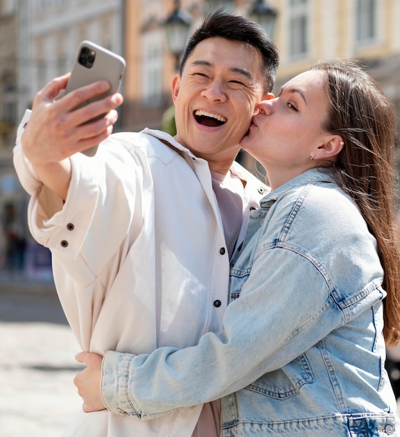 Medium shot romantic couple taking selfie