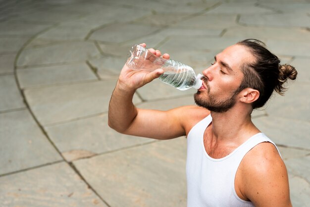 Medium shot of runner drinking water