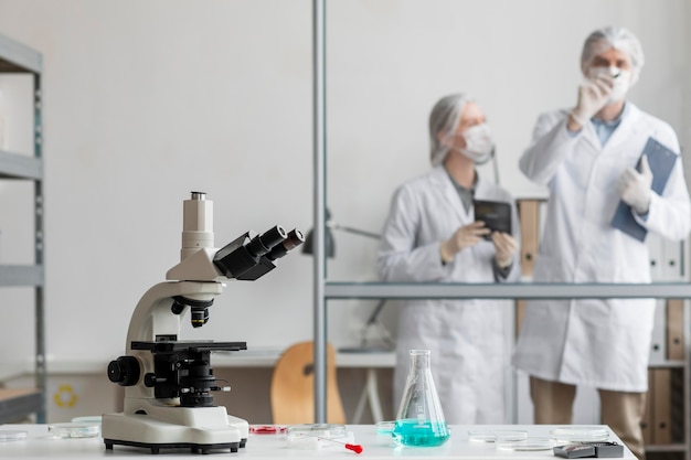 Medium shot scientists discussing in lab