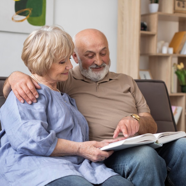 Medium shot senior couple holding book