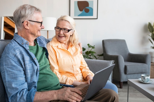 Free photo medium shot senior couple with laptop