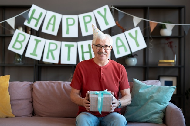 Medium shot senior man holding present