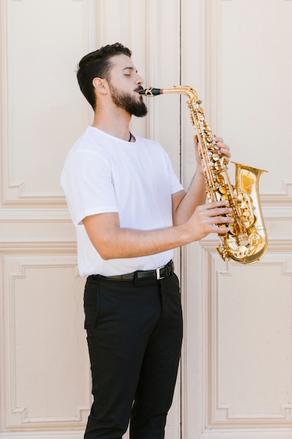 Free photo medium shot sideways musician playing the sax