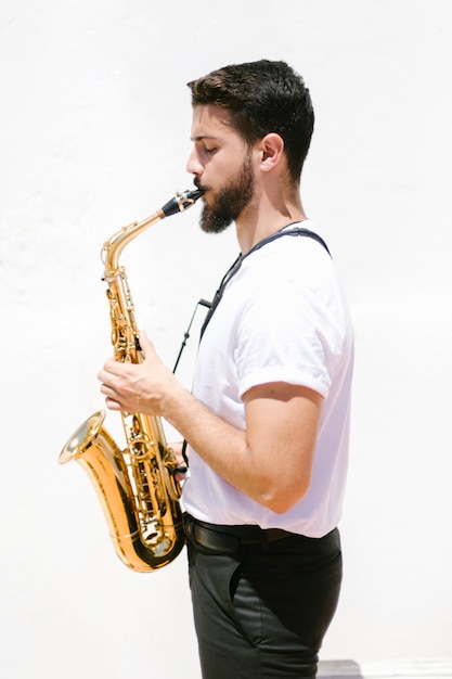 Free Photo medium shot sideways musician playing the saxophone