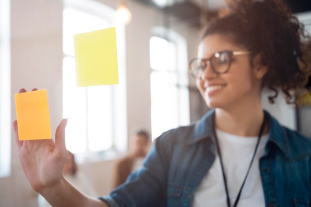 Medium shot smiley business woman with post its