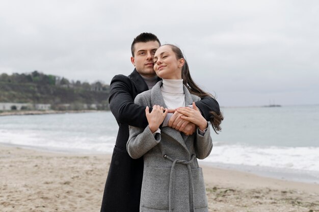 Medium shot smiley couple on beach