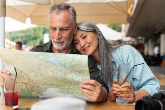 Medium shot smiley couple holding map