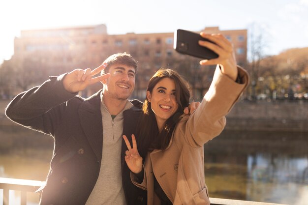 Medium shot smiley couple taking selfie