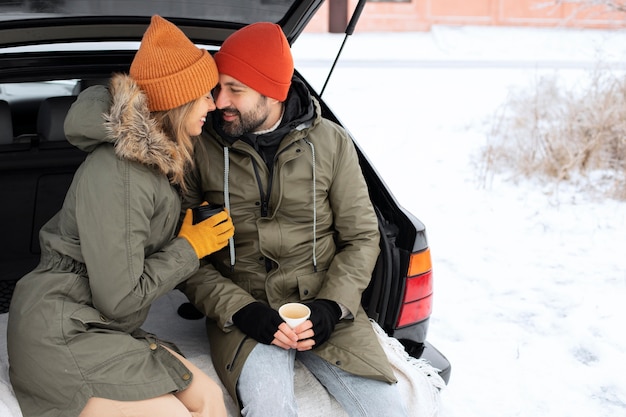 Medium shot smiley couple with car