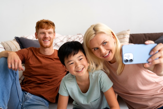 Medium shot smiley family taking selfie