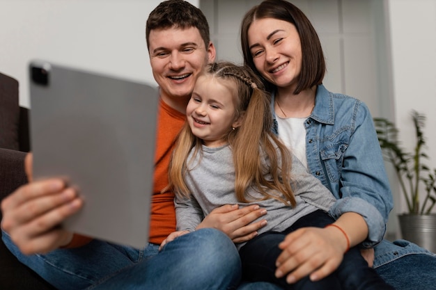 Medium shot smiley family with laptop