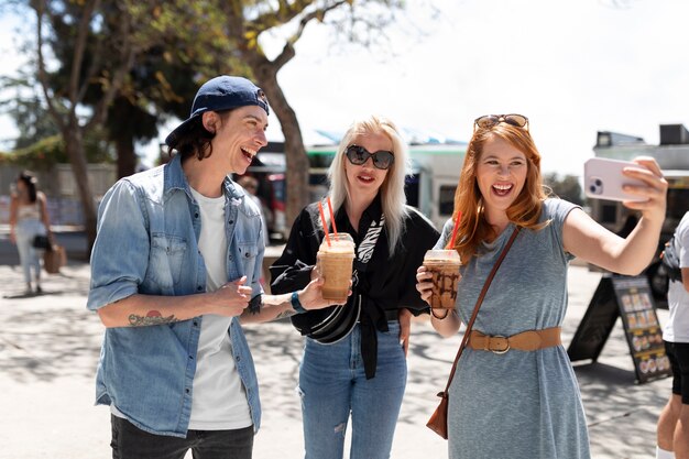 Medium shot smiley friends taking selfie