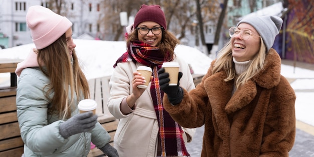 Medium shot smiley friends with coffee cups