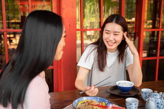 Medium shot smiley friends with tasty food