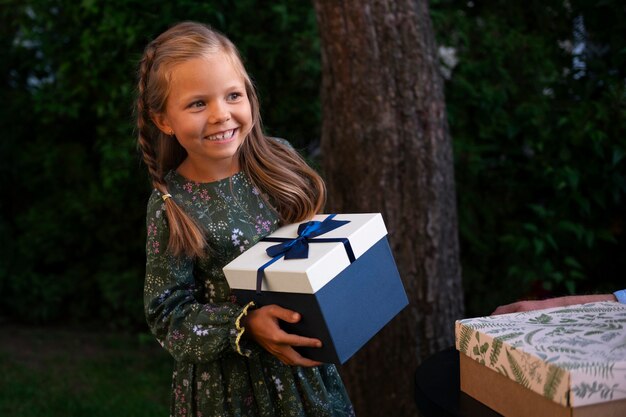 Medium shot smiley girl holding gift