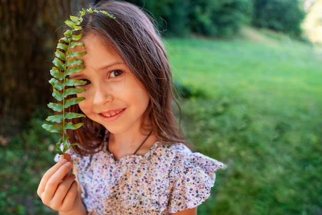 Medium shot smiley girl holding leaf