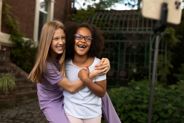 Medium shot smiley girls hugging