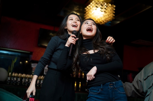 Free photo medium shot smiley girls singing