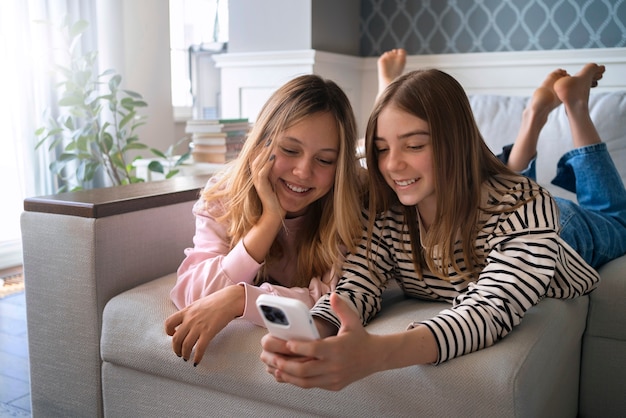 Medium shot smiley girls with devices