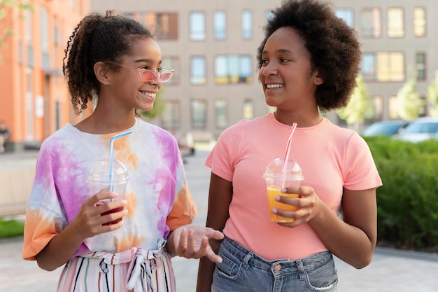 Medium shot smiley girls with drinks