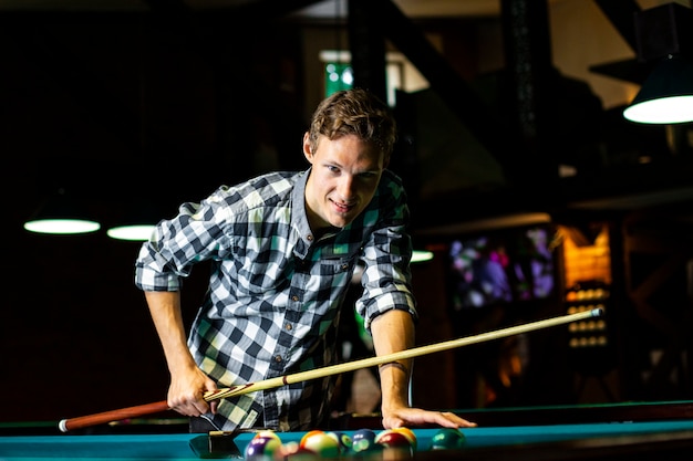 Medium shot smiley guy with pool cue 