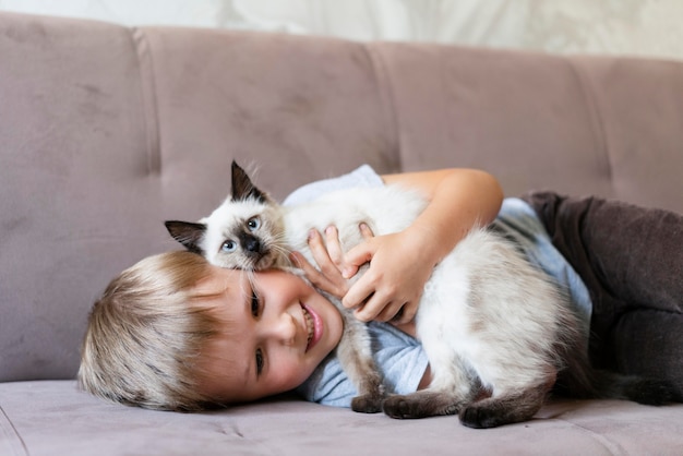 Medium shot smiley kid holding cute cat