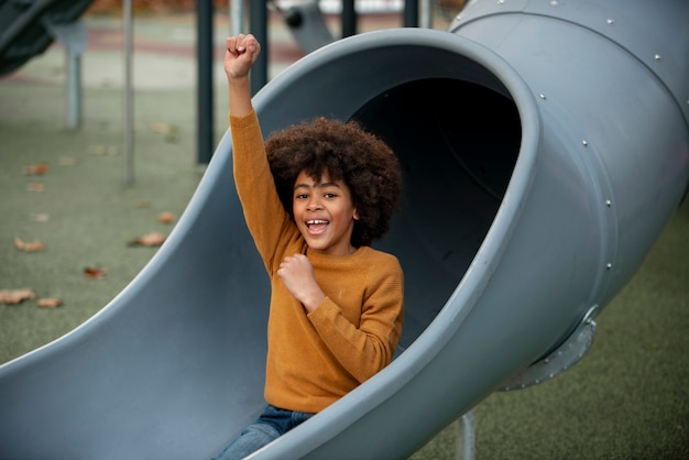 Medium shot smiley kid on slide