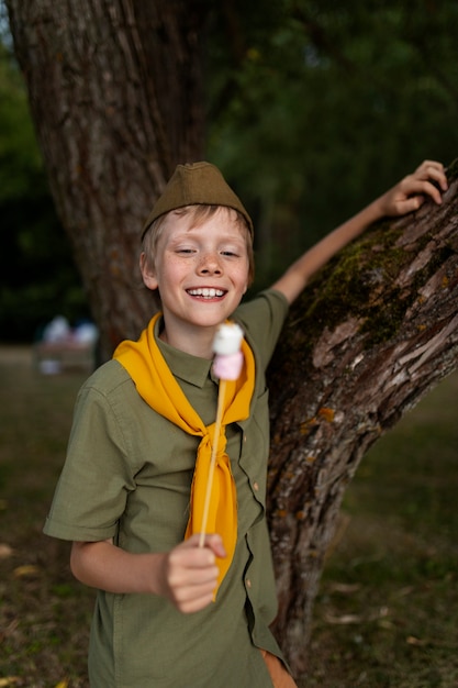 Free photo medium shot smiley kid with marshmallows