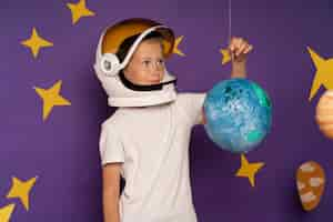 Free photo medium shot smiley kid with planet