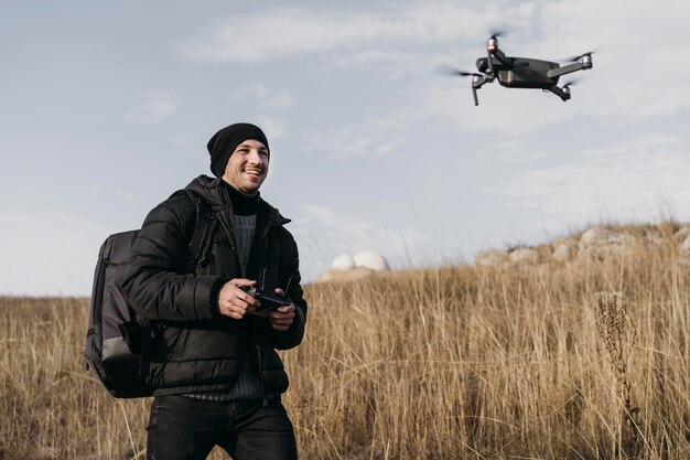 Medium shot smiley man controlling drone