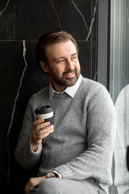 Free Photo medium shot smiley man holding coffee cup