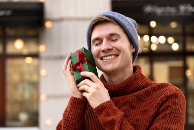 Medium shot smiley man holding gift