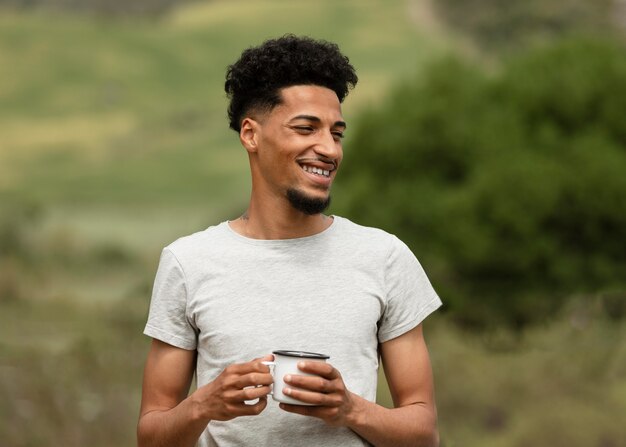 Medium shot smiley man holding mug