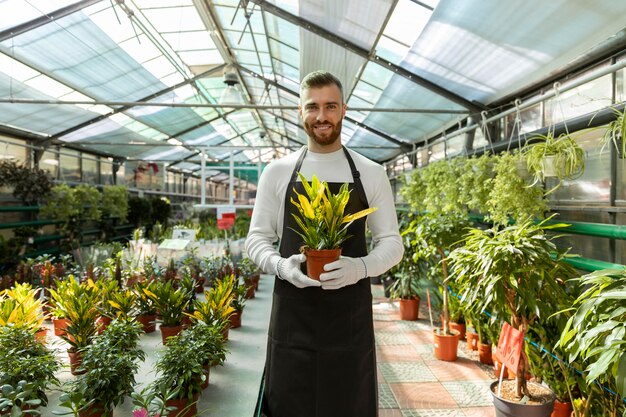 Medium shot smiley man holding plant