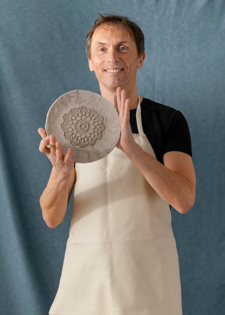 Free photo medium shot smiley man holding plate