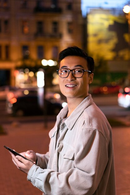 Medium shot smiley man holding smartphone