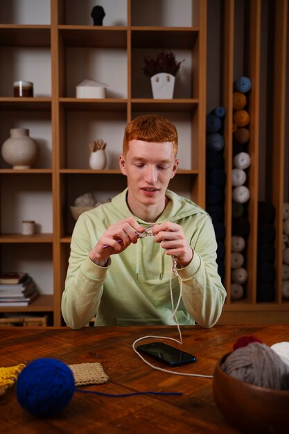 Medium shot smiley man knitting