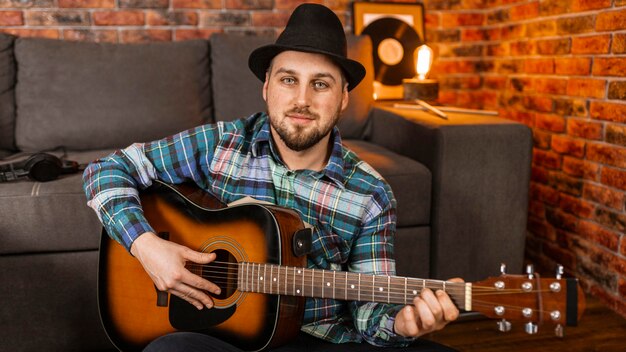 Free photo medium shot smiley man playing the guitar