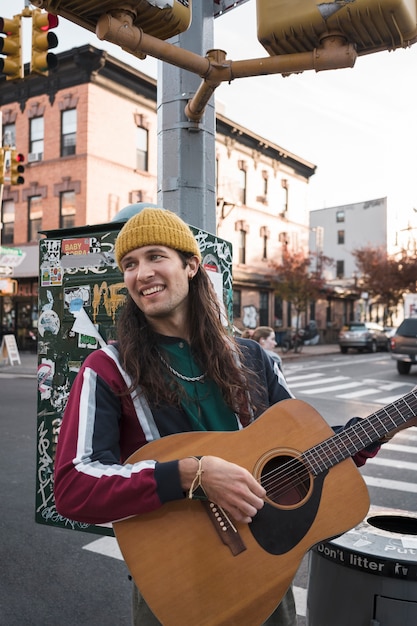 Free photo medium shot smiley man playing the guitar