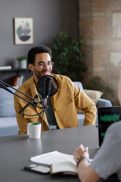 Medium shot smiley man at podcast