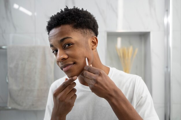 Medium shot smiley man using gua sha tool