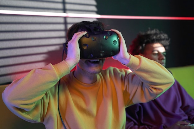 Free photo medium shot smiley man wearing vr glasses