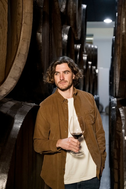 Free photo medium shot smiley man in wine cellar